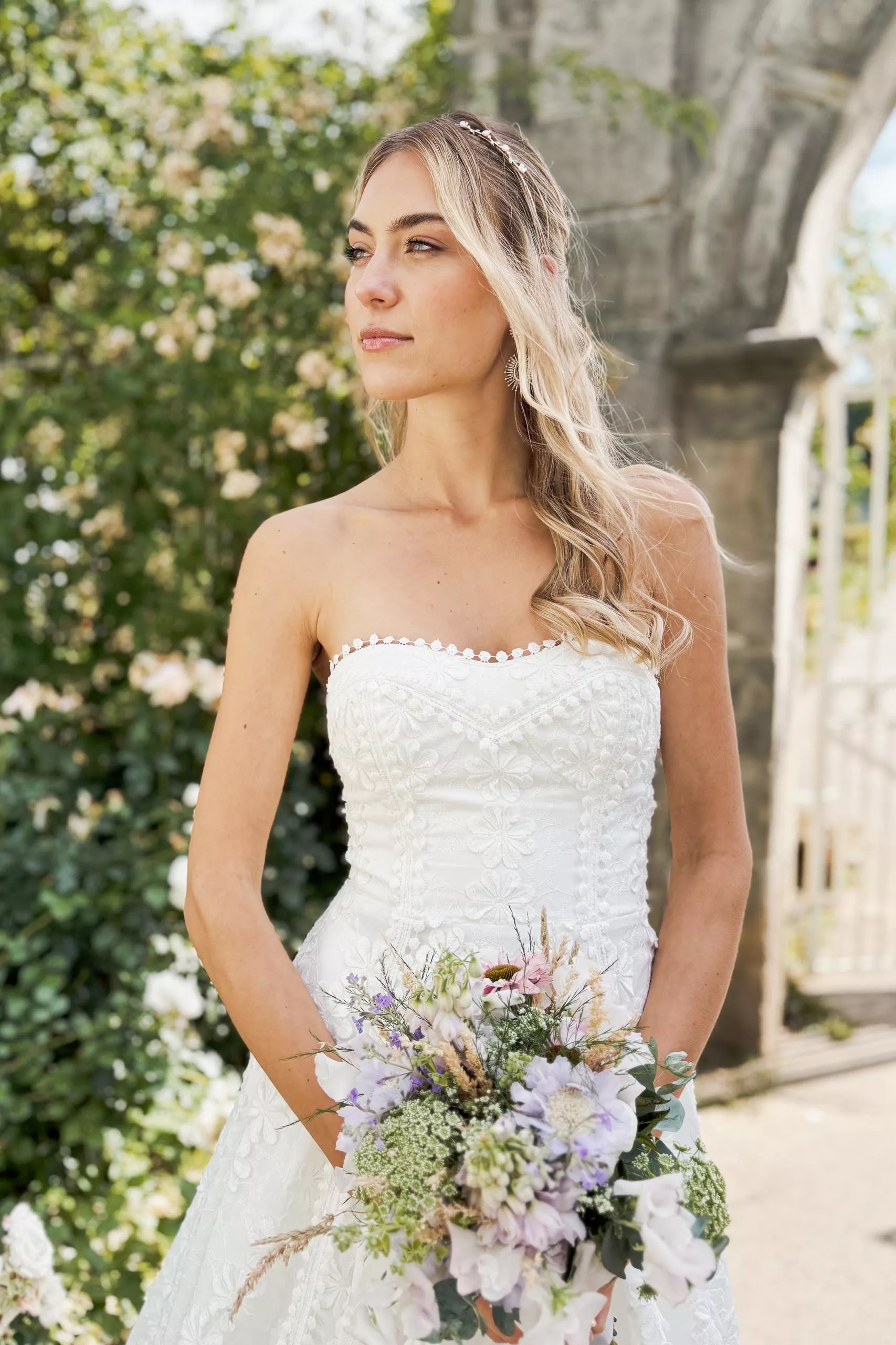Braut im schulterfreien Kleid mit Blumenstrauß